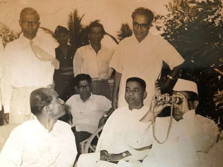 This photograph was taken at Pansare's (seated in the far-left corner) home and studio in Bandra (E). Here, Shri Balasaheb Desai is using an inverted binocular to view the whole statue of Chhatrapati Shivaji Maharaj; Source: Pansare Family Archive